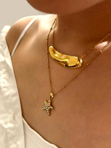 Close-up of double layer gold stainless steel necklace with star pendant and rhinestones