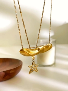 Close-up of golden irregular bar and star pendant necklace with sparkling rhinestones