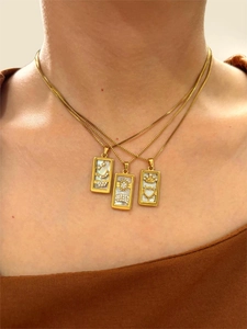 Detailed view of layered gold tarot pendants with white shell inlay and zircon accents