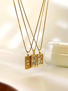 Detailed close-up of gold tarot pendant necklaces with white shell inlay and crystals