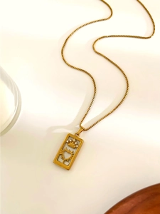 Detail of vintage gold rectangular pendant with crown and sunburst heart engraving