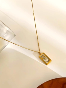 Close-up of golden tarot pendant necklace featuring sun and moon shell inlay and zircons