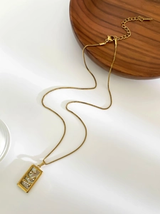 Detail of gold tarot square pendant with white shell inlay, star and moon stones on box chain