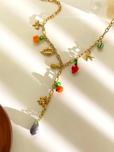 Detail der Goldkette mit bunten Obstanhängern wie Ananas- und Chili-Anhängern