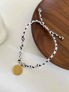 Détail d'un bracelet en corde tressée ajustable avec disque gravé I AM PROTECTED