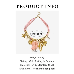 Dettaglio della collana intrecciata rosa con stelle marine conchiglie e ciondoli corallo