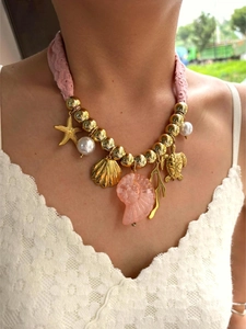 Dettaglio della collana in corda rosa con pendente a conchiglia e stelle marine