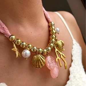 Collana con cordino intrecciato rosa con ciondoli dorati a forma di stella marina e tartaruga