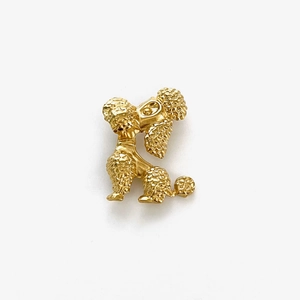 Close-up detail of golden poodle brooch with fine curly fur texture and elegant design