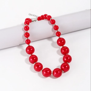 Detailed view of large red imitation pearls with silver metal spacers and a lobster clasp