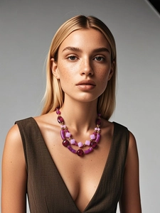 Detail of chunky double-layer beaded necklace in purple and gold on a model