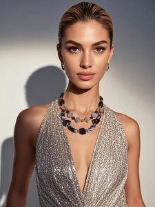 Close-up of chunky layered necklace with black resin beads and blue marble stones