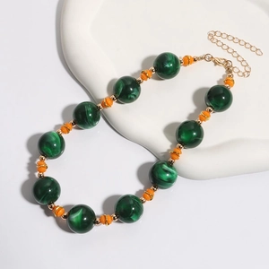 Grote donkergroene marmeren kralenketting met oranje accenten en gouden metalen ketting