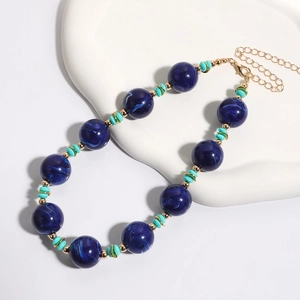 Detail van blauwe marmeren kralenketting met gouden karabijnsluiting en verstelbare ketting