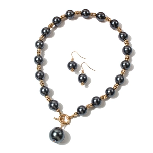 Dettaglio del set collana e orecchini di perle grigio scuro con distanziali dorati e strass