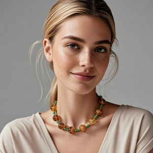 Bohemian halsketting met grote amberkleurige harskralen en groene tussenringen aan model
