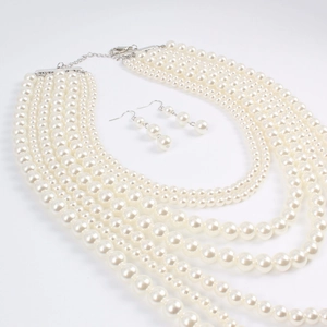 Détail du collier de perles multicouches et des boucles d'oreilles assorties polies