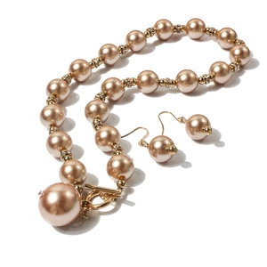 Dettaglio della collana di perle color champagne con accenti di cristallo e chiusura a T