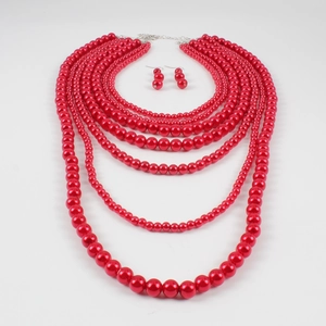Détail d'un collier de perles rouges multicouches avec boucles d'oreilles assorties