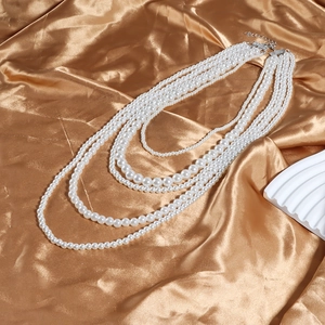 Détail d'un collier de perles blanches multicouches avec fermoir réglable en argenté