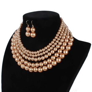 Elegant multi-layer champagne pearl necklace and matching earrings set on a black bust
