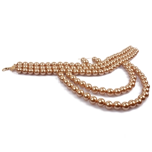 Detailed close-up of multi-layer champagne pearl necklace with a golden lobster clasp