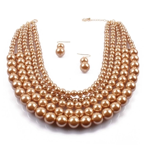Detailed view of the five-layer champagne gold faux pearl necklace with matching earrings