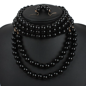 Detail of elegant multilayer black pearl necklace set with matching hook earrings