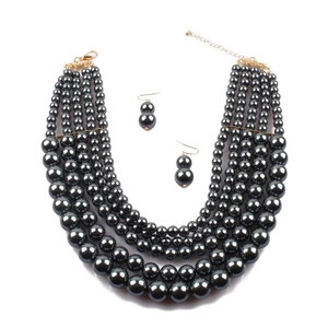 Detail of multi-layer black pearl necklace set with elegant golden metal clasps and earrings