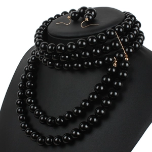 Close-up of multi-layer black pearl necklace and matching earrings on a display
