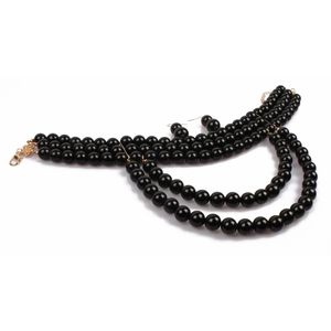 Detail of three-layer black faux pearl necklace with matching round bead earrings
