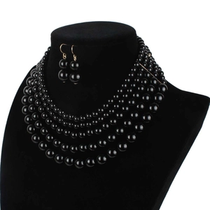 Detail view of a multi-layer black pearl necklace and matching drop earrings on a bust