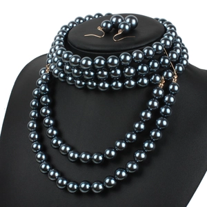 Close-up of a multi-layer dark grey pearl necklace and matching earrings set on a black bust