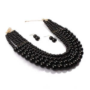 Macro shot of 5-layer polished black faux pearl necklace with gold metal lobster clasp