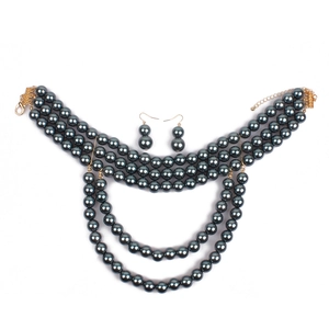 Macro detail of multi-layer faux pearl necklace set with golden lobster clasp and earrings