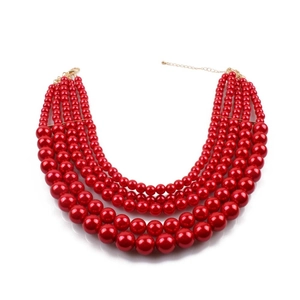 Detail of five-layer red faux pearl necklace with graduated beads and gold clasp