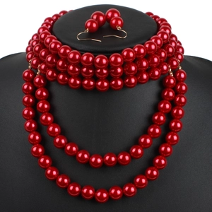 Elegant red multi-layer faux pearl necklace and earring set on a black display bust