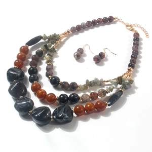 Dettaglio della collana di perle multistrato con marmo nero e pietre di agata marrone