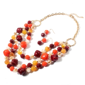 Détail du collier bohème à plusieurs rangs et boucles d'oreilles aux tons d'automne