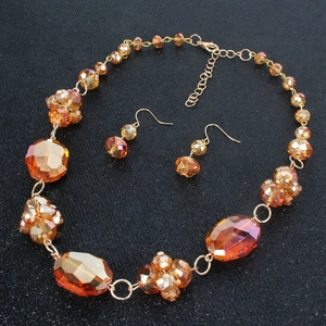 Detail von bernsteinfarbenem Kristall Halskette und Ohrring Set mit goldener Legierung auf Schwarz