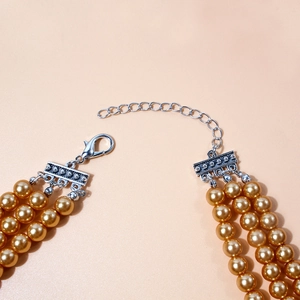 Detailopname van drielaagse parelketting met champagne parels en zilveren sluiting