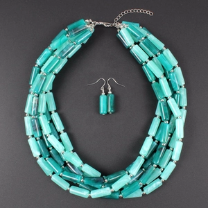 Detalle de collar y pendientes de cuentas azul cerceta con textura de mármol y cierre
