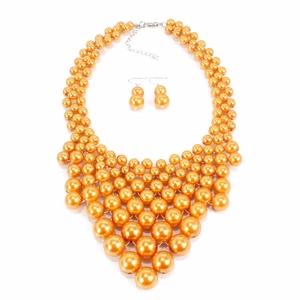 Détail d'un collier plastron multicouche en perles orange et boucles d'oreilles assorties