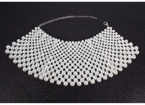 Detalle del collar de perlas blancas tejidas de varias capas con cierre de metal plateado