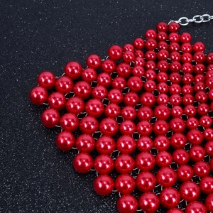 Primer plano del collar de perlas rojas tejidas con cierre de langosta plateado de moda