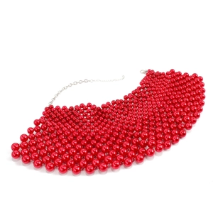 Detalle del collar de pechera de perlas rojas tejidas con cadena ajustable y cierre de langosta