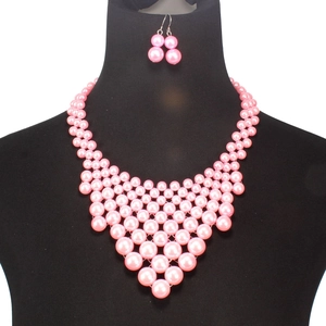 Parure collier plastron multicouche et boucles d'oreilles en perles roses sur buste