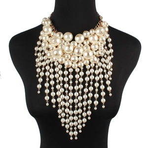Close-up of multilayer faux pearl fringe necklace with golden cascading waterfall tassels