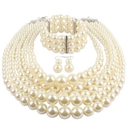 Detalle de un conjunto de perlas crema multicapa con collar, pulsera y pendientes a juego