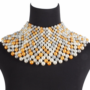 Collar de chal de perlas tejidas con capas blancas y doradas sobre un maniquí de joyería